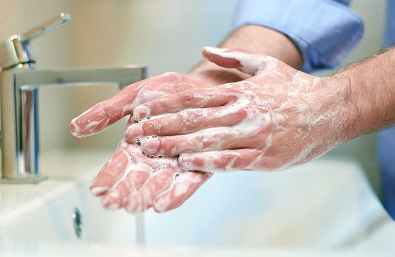 Hände werden am Waschbecken mit Seife gewaschen